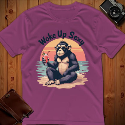 Pink t-shirt with a monkey graphic and 'Woke Up Sexy' text on a wooden surface.